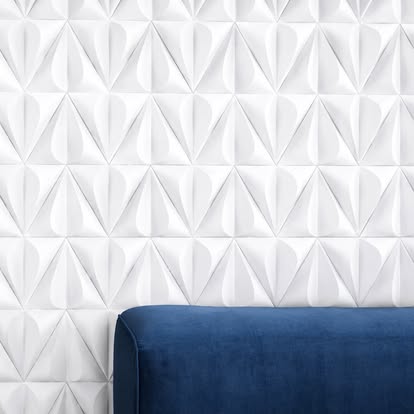 White dimensional geometric tile feature wall behind a blue seat